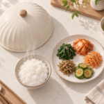 전자레인지 위에서 뜨거운 밥과 반찬 옆에 놓인 아이보리색 푸드커버 개념도