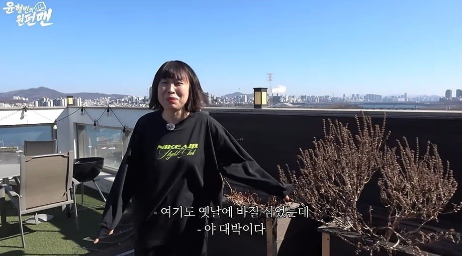 윤형빈의 원펀맨 영상 속 오나미가 테라스에서 한강 쪽을 소개하는 장면